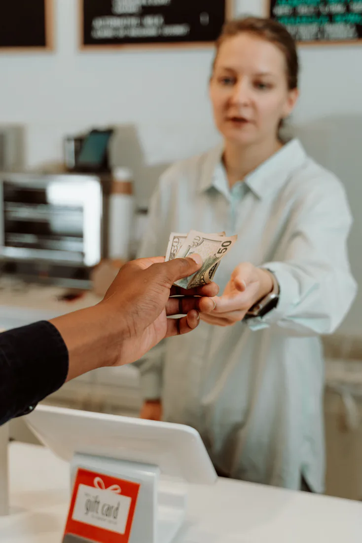 Cashier serving a customer at a real retail counter